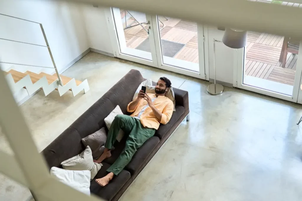 Man lying on a sofa looking at his phone